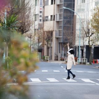 信号を手を挙げて渡る人